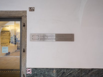 Centro visite Puez-Odle Ingresso alla galleria civica Bressanone con informazioni sulla mostra sulla porta di vetro