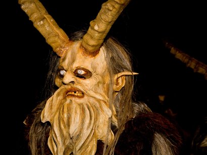 Etimologia del termine Törggelen Figura mascherata con grandi corna e occhi bianco-blu su sfondo scuro