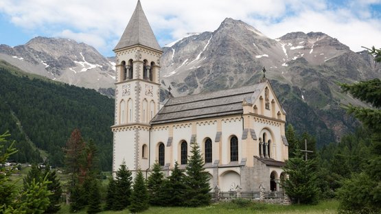 Hotels in Sulden: Urlaub am Ortler Kirche in den Alpen mit Bergen und Wald im Hintergrund