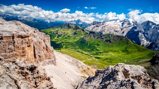 Hotels Vinschgau: Wandern und Skifahren in Südtirol Blick auf steile Felsen und grüne Täler in den Dolomiten bei klarem Himmel