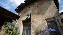 Hotel a Merano in Alto Adige Vecchia casa rustica con porte di legno, piante e fiori blu in primo piano