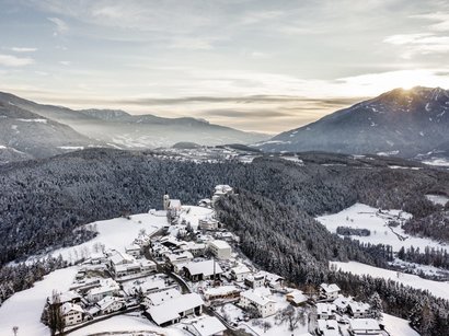 Villanderer Alm im Eisacktal Dorf und verschneite Wälder in einem Tal mit Bergen im Hintergrund