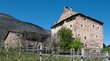 Il museo dedicato alla cultura medievale Vecchia casa di pietra davanti a una montagna alberata sotto un cielo blu limpido