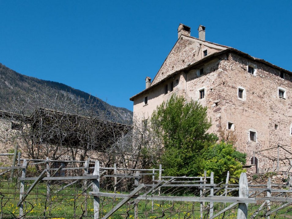 Das Museum für mittelalterliche Wohnkultur Altes steinernes Bauernhaus vor bewaldetem Berg unter klarem blauem Himmel