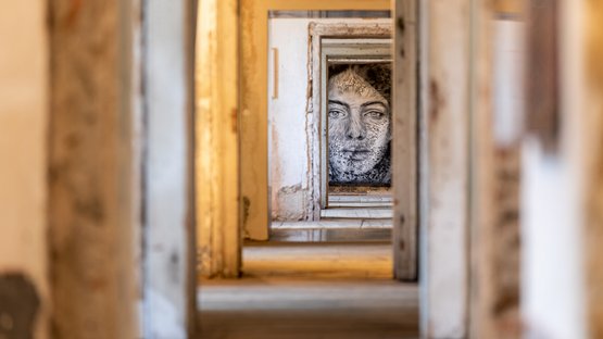 Forte di Fortezza Volto dipinto visto attraverso diverse porte in un edificio abbandonato