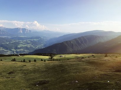 Lago artificiale di Fortezza Prato verde con montagne sullo sfondo sotto un cielo limpido