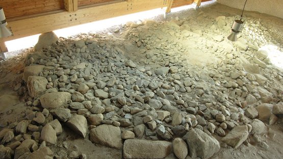 Archeoparc Feldthurns Archäologische Ausgrabungsstätte mit Steinmauer und Holzdach