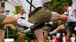 Goaslschneller e Schuahplattler Uomini che ballano in abiti tradizionali bavaresi alzano le gambe contemporaneamente