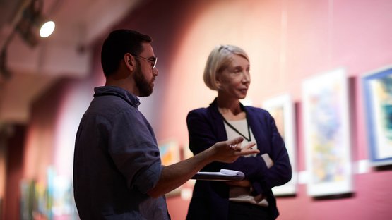 Das Museum Mansio Sebatum Zwei Personen diskutieren vor Kunstwerken in einer Galerie