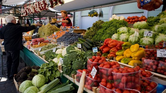 Mit dem Stegener Markt bereit für den Winter Frischer Obst- und Gemüsestand auf einem Markt mit einem Kunden und Verkäuferin