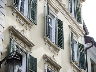 Hotel a Scena presso Merano Facciata di casa gialla con persiane verdi in stile storico