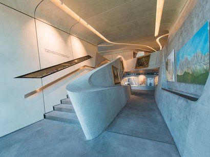 Hotel a San Lorenzo in Val Pusteria Corridoio di museo moderno con pareti in cemento e quadri esposti