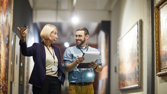 Das Nationalparkhaus Lahnersäge Zwei Museumsmitarbeiter diskutieren vor Gemälden im Kunstmuseum