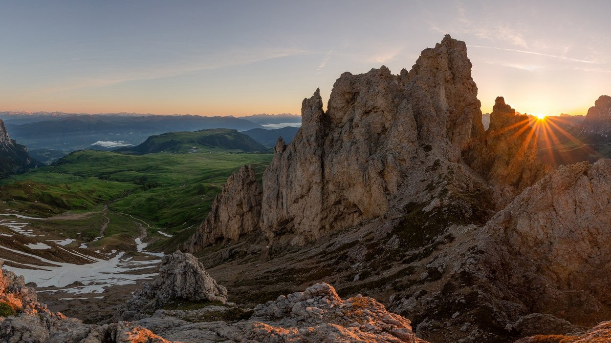 Hotels in den Dolomiten in Südtirol Sonnenuntergang über felsigen Bergen und grünen Tälern in den Alpen