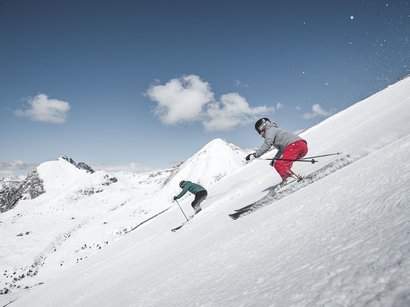 Skispaß im urigen Pfelders Zwei Skifahrer auf schneebedecktem Berg bei sonnigem Himmel