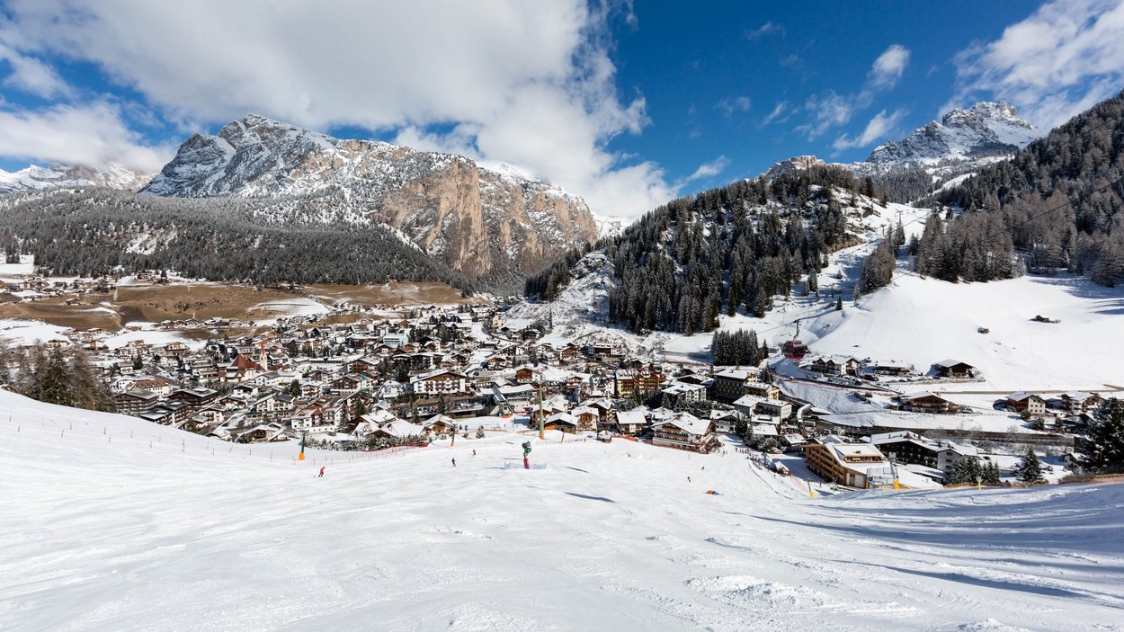 Gröden - Paradies für Langläufer Schneebedeckte Stadt mit Bergen und Skifahrern im Winter