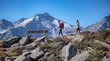 Ihre traumhaften Hotels im Ahrntal in Südtirol Zwei Wanderer gehen auf felsigem Bergpfad mit Bank und Alpenim Hintergrund