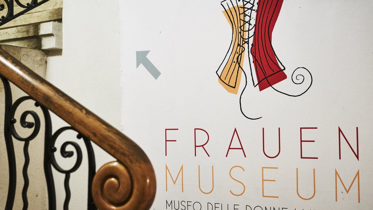 Museo delle donne di Merano Cartello che indica il Museo delle Donne a Merano con ringhiera decorativa