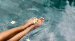 Hotel di Lusso in Alto Adige - Eleganza & Servizio Piedi con smalto bianco e fiore nell'acqua trasparente della piscina