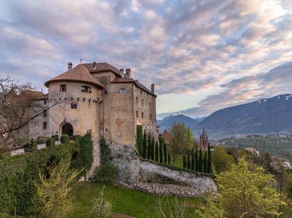 L’imponente Castel Wehrburg in Alto Adige Vecchio castello su una collina con vista sulla valle e montagne sotto un cielo nuvoloso