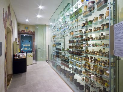 La miniera di Villandro, un pezzo di storia Esposizione museale con scaffali in vetro pieni di antichi contenitori farmaceutici