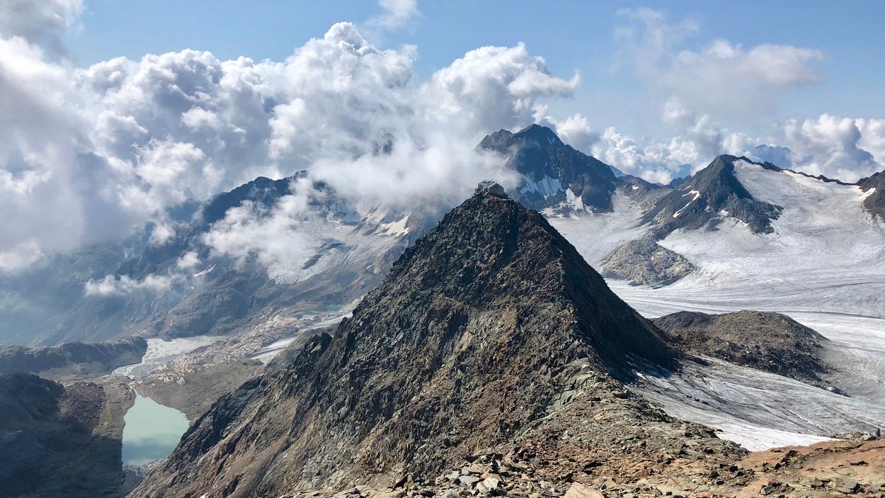 Rifugio Bicchiere: un rifugio sulle Alpi dello Stubai Cima di montagna con rifugio e ghiacciaio sotto un cielo nuvoloso