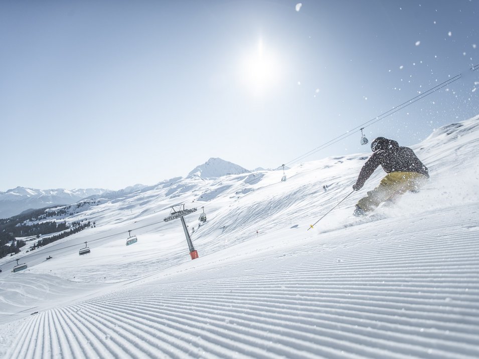 Area sciistica Racines-Giovo: divertimento invernale senza limiti Scia sulla pista appena battuta in una stazione sciistica soleggiata