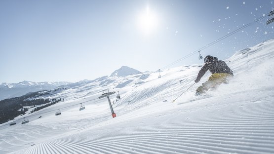 Area sciistica Racines-Giovo: divertimento invernale senza limiti Scia sulla pista appena battuta in una stazione sciistica soleggiata
