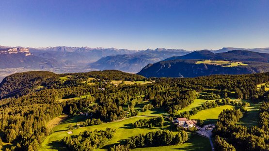 Golfclub Petersberg Luftaufnahme eines grünen Golfplatzes in den Bergen unter klarem blauem Himmel