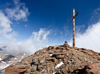 360 °-Blick von der Zufrittspitze in Südtirol Gipfelkreuz auf felsigem Berggipfel unter blauem Himmel mit Wolken