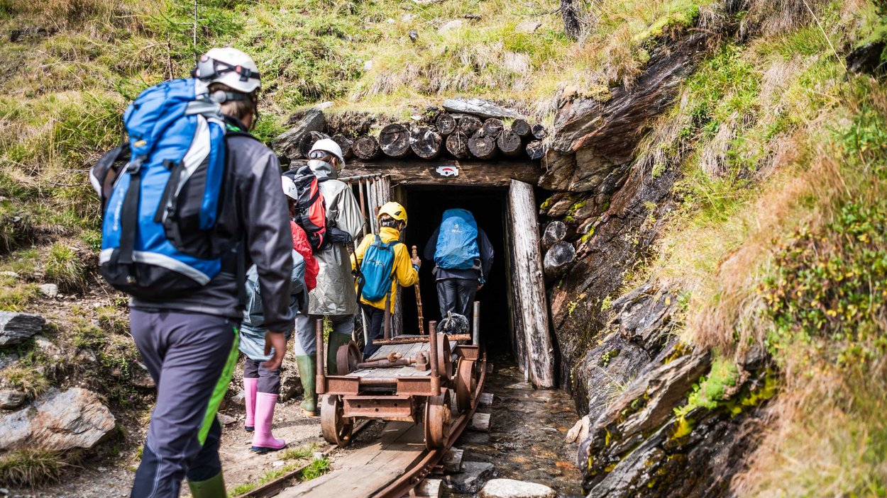 Das Bergbaumuseum am Schneeberg Gruppe von Menschen mit Helmen betritt Stolleneingang in den Bergen