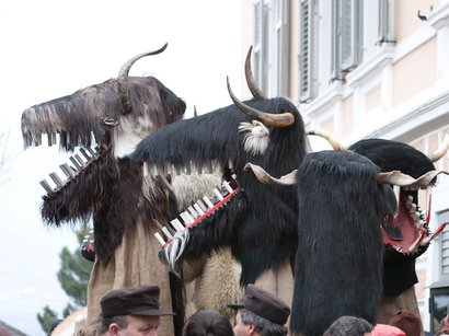 Etimologia del termine Törggelen Tre grandi maschere tradizionali con corna e denti finti in una sfilata