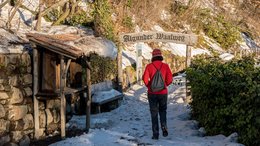 Ihre Hotels in Meran in Südtirol: Hotels im Meraner Land Person wandert auf schneebedecktem Algunder Waalweg im Winter