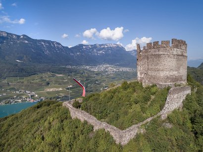 Castel Corba ad Appiano Rovina di castello su collina verde con vallata e montagne sullo sfondo