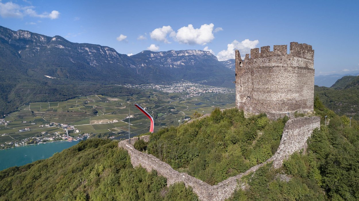 Die Leuchtenburg bei Kaltern Burgruine auf bewaldetem Hügel mit weitem Tal und Bergen im Hintergrund