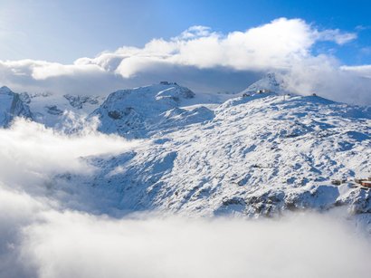 Avventure e piacere nell’area sciistica della Val Senales Montagne innevate con nuvole e cielo azzurro