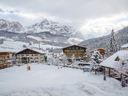 Rundloipe blau Schneebedecktes Dorf in den Bergen mit Häusern und verschneiten Bäumen