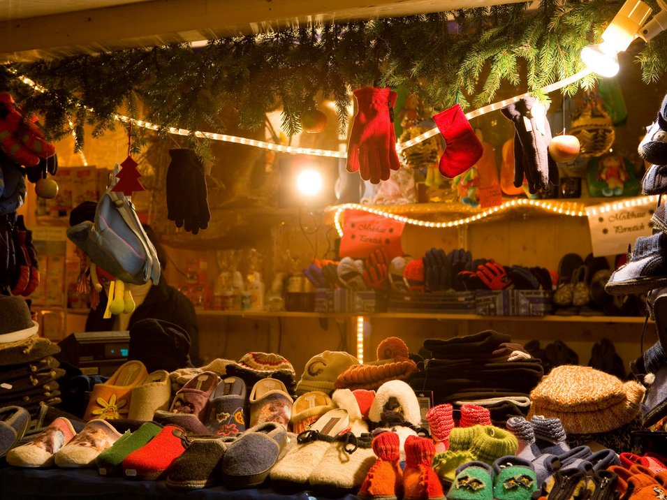 Die Christkindlmärkte im Grödner Tal Weihnachtsmarktstand mit Handschuhen, Hausschuhen und gestrickter Winterkleidung