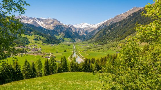 Hotel a Ridanna in Alto Adige Valle verde con fiume, foreste e montagne innevate sotto un cielo azzurro limpido