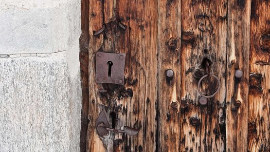 Schloss Katzenstein bei Meran Nahaufnahme einer alten hölzernen Tür mit rostigem Schloss und Türklopfer