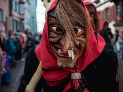 Hotels in Alta Badia: Urlaub durch und durch Hölzerne Hexenmaske mit rotem Kopftuch bei Straßenumzug