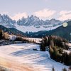 Hotel in Alto Adige 😎☀️ Per vacanze indimenticabili Prato innevato davanti alle Dolomiti con case illuminate dal sole