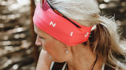 16a DYNAFIT Transalpine Run 2021 - 7a tappa: dall'Engadina svizzera alla Val Venosta in Alto Adige Donna con fascia rossa e occhiali da sole in una foresta