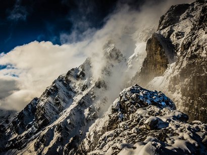 Vie ferrate in Alto Adige Cime innevate con nuvole sotto un cielo scuro