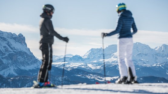 Das Skigebiet Kronplatz im Herzen der Dolomiten Zwei Skifahrer blicken auf verschneite Berglandschaft bei klarem Himmel