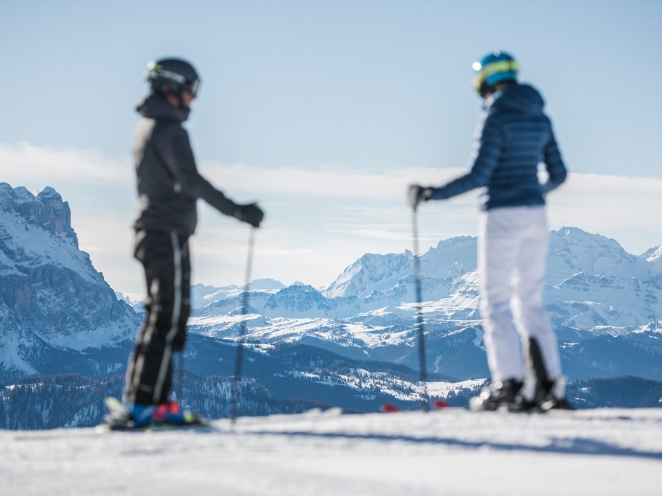 Das Skigebiet Kronplatz im Herzen der Dolomiten Zwei Skifahrer blicken auf verschneite Berglandschaft bei klarem Himmel