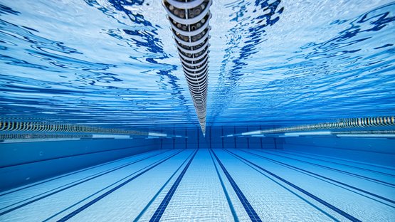 Alpin Erlebnisbad Acquafun in Innichen Unterwasseraufnahme eines leeren Schwimmbeckens mit Bahnenmarkierungen