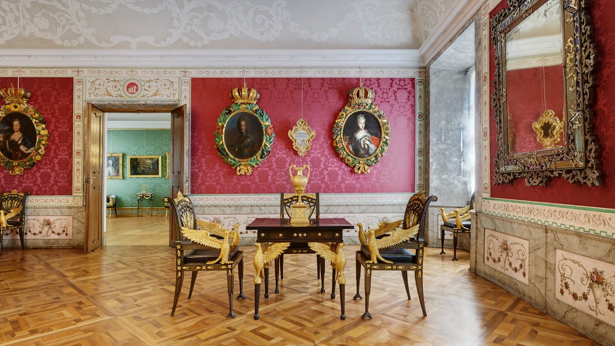 Diözesanmuseum Hofburg Brixen Prunkvoll eingerichteter Raum mit roten Wänden, goldverzierten Stühlen und Gemälden