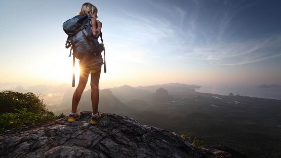 Laufstrecke Oberer Panoramaweg Jaufental Wanderin steht auf Felsen und blickt auf Landschaft bei Sonnenuntergang