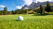 The mountain beast for golfers Golfball auf Gras mit Bergen und blauem Himmel im Hintergrund